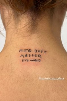 a woman's back neck with the words mind over matter written in black ink