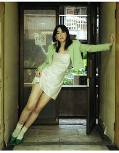 a woman posing in front of an open door with her legs spread out and arms outstretched