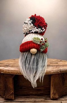 a knitted gnome hat on top of a wooden table with an ornament