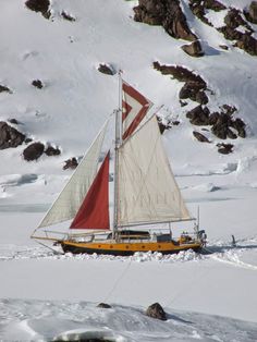 a sailboat floating on top of snow covered ground