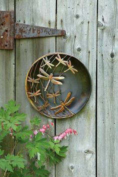 an instagram photo with a plate and flowers on the wall next to wooden fence