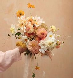 a woman holding a bouquet of flowers with the words here and now written in cursive writing