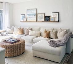 a living room filled with lots of furniture and pillows on top of a white rug