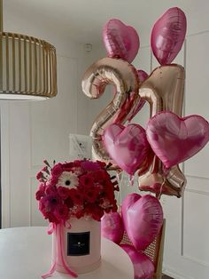 a table topped with balloons and flowers on top of it