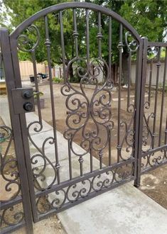 an iron gate is open on the sidewalk