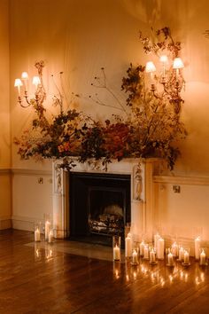 a fireplace with candles and flowers on it