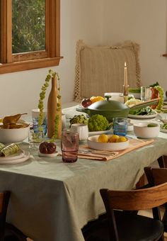 a dining room table is set with plates and bowls