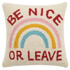 a pillow with the words be nice or leave in red, yellow and blue on it