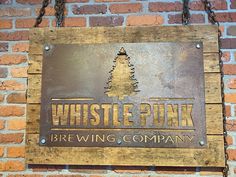 a sign that is on the side of a brick wall saying whistle punk brewing company