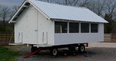 a small white house sitting on top of a trailer