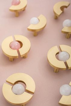 several pieces of art made out of wood on a pink surface with one object in the middle