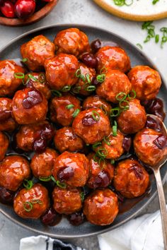 meatballs with cranberry sauce and fresh herbs in a bowl on a table