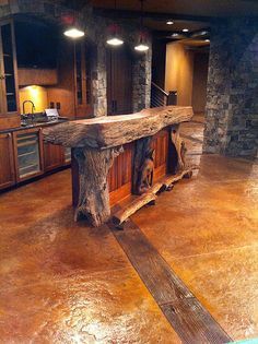 a large wooden table sitting in the middle of a living room next to a kitchen