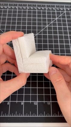 someone is making a miniature white object out of foam