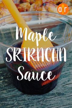 a wooden table topped with a glass bowl filled with sauce