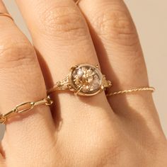 a woman's hand with a gold ring on it and a diamond in the middle