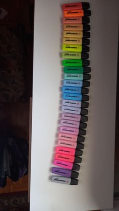 a row of markers sitting on top of a white board next to a wall in a room