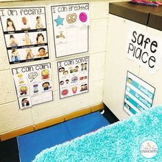 a bulletin board with pictures on it next to a blue rug and a white refrigerator