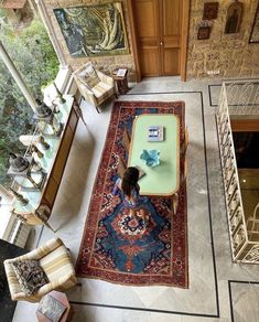 a woman sitting on top of a rug in a living room