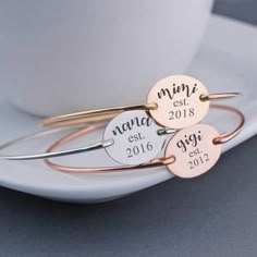 three personalized bang bracelets sitting on top of a white plate next to a cup