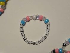 two bracelets with words written on them and some beads attached to the bead