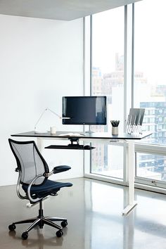 an office chair sits in front of a desk with a computer monitor and keyboard on it