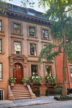 an old brownstone building with many windows and steps leading up to the front door