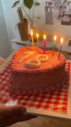 a heart shaped cake with lit candles on it in the shape of a number 50