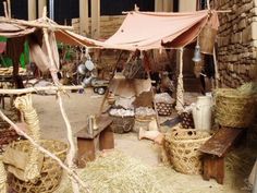 an outdoor area with straw and other items on display, including umbrellas and baskets