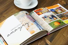 an open book on a wooden table next to a cup and saucer