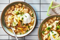 two bowls filled with beans and vegetables on top of a table