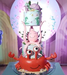 a three tiered cake decorated with an octopus and crab on it's side