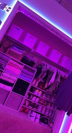 the closet is filled with shoes and other items in purple lighting, including t - shirts