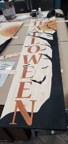 a large wooden sign with the word halloween painted on it