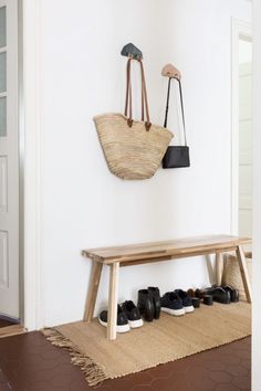 a wooden bench sitting next to a wall with shoes hanging from it's hooks