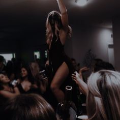 a woman standing on top of a chair in front of a crowd