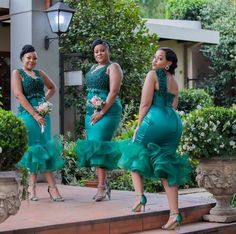 three women in green dresses standing on steps