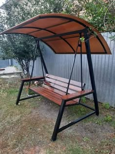 a wooden bench sitting next to a metal fence