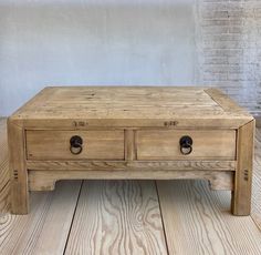 a wooden coffee table with two drawers on top