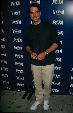 a man standing in front of a blue wall with the words peta on it