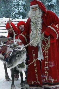 a man dressed as santa claus with reindeers in the snow