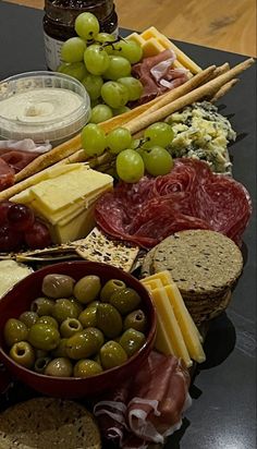 an assortment of cheeses, meats and olives on a platter