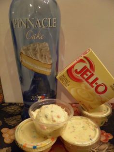 cupcakes and ice cream are sitting on a table next to a blue bottle