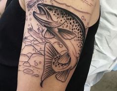 a woman's arm with a fish tattoo on it