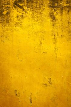 an old yellow wall with some paint on it