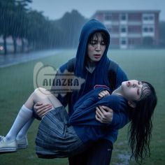 two people are sitting in the rain with their arms around each other and one person is holding another