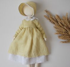 the doll is wearing a yellow dress and hat