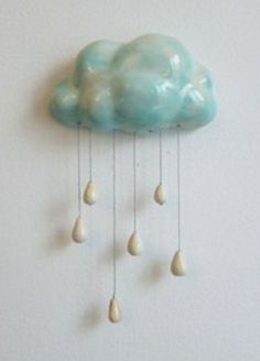 there is a blue cloud with white drops hanging from it's sides on the wall