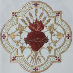 an embroidered heart on a white background with gold trimmings and red flowers in the center