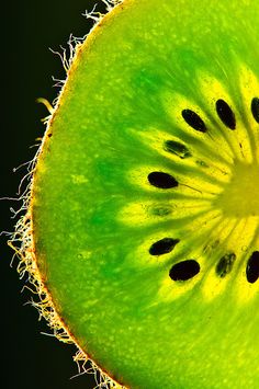 a close up view of the inside of a kiwi's slice, with black dots